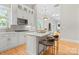 Modern kitchen with white cabinets, gold hardware, an island with seating, and stainless steel appliances at 4015 Randolph Rd, Charlotte, NC 28211