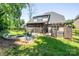 Backyard featuring fire pit, screened porch, hot tub, and landscaped lawn with mature trees at 4017 Halyard Dr, Denver, NC 28037