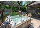 Hot tub area next to screened porch, featuring a pergola, lush landscaping, and cozy outdoor setting at 4017 Halyard Dr, Denver, NC 28037