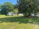 A grassy backyard featuring an outbuilding, and beautiful foliage at 408 Moose St, Albemarle, NC 28001