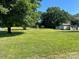 Expansive front yard with lush lawn, mature trees, and outbuilding at 408 Moose St, Albemarle, NC 28001