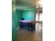Green room with a dark wooden dresser, linoleum flooring, and an open doorway to another room at 408 Moose St, Albemarle, NC 28001