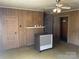 Living room featuring a vintage heater, wood-paneled walls, and a decorative fireplace mantle at 408 Moose St, Albemarle, NC 28001