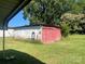 View of the property's red and white outbuilding with overgrown lawn at 408 Moose St, Albemarle, NC 28001