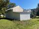 Rustic shed featuring weathered white paint and a corrugated metal roof, amidst a grassy yard at 408 Moose St, Albemarle, NC 28001