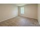 Bright bedroom with neutral carpet and walls, featuring a window with a view of the outdoors at 414 1St Avenue Se None, Hickory, NC 28602