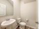 Neat half bathroom with a white pedestal sink, toilet, and neutral decor at 414 1St Avenue Se None, Hickory, NC 28602