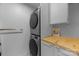 Efficient laundry room with a stacked washer and dryer and a functional wooden countertop at 415 N Church St # 311, Charlotte, NC 28202