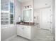 Clean bathroom featuring white cabinetry, a large mirror, and marble floors at 4237 Island Fox Ln, Denver, NC 28037
