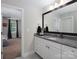 Bathroom vanity with granite countertop, white cabinets, and a large framed mirror at 4237 Island Fox Ln, Denver, NC 28037