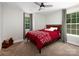 Cozy bedroom with a red patterned comforter, two windows and a ceiling fan, creating a bright and inviting space at 4237 Island Fox Ln, Denver, NC 28037