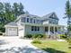 Beautiful two-story home with a front porch, three-car garage, and well-manicured lawn at 4237 Island Fox Ln, Denver, NC 28037