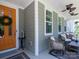 Cozy front porch with wicker chairs, neutral siding, and a decorative front door at 4237 Island Fox Ln, Denver, NC 28037
