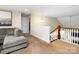 Open loft area featuring neutral tones, a comfortable sofa, and a view of the staircase, ideal for relaxation at 4237 Island Fox Ln, Denver, NC 28037