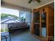 Covered patio with a comfortable wicker couch and a sauna, creating an ideal space for outdoor relaxation and wellness at 4237 Island Fox Ln, Denver, NC 28037