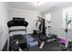 Well-equipped home gym with a treadmill, weight machines, and rubber flooring at 4237 Island Fox Ln, Denver, NC 28037