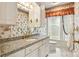 Well-lit bathroom featuring decorative wallpaper, white cabinets and granite countertops at 441 Wildlife Club Ln, Taylorsville, NC 28681