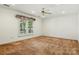 A bright bedroom features a ceiling fan and a large window with white shutters at 441 Wildlife Club Ln, Taylorsville, NC 28681