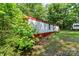 Exterior side view with lush greenery all around, offering a secluded and peaceful setting at 5239 Lineberger Rd, Stanley, NC 28164