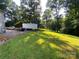 Picturesque backyard with an outbuilding, lush green grass, and mature trees at 5570 George Henry Dr, Hickory, NC 28602