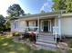 Charming front porch with rocking chairs, American flag and fresh landscaping at 5570 George Henry Dr, Hickory, NC 28602