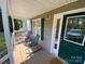 Inviting front porch with rocking chairs, complemented by a stylish green door and detailed trim at 5570 George Henry Dr, Hickory, NC 28602