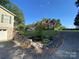 Expansive front yard featuring lush greenery, rock accents, and a spacious driveway leading to the house at 5570 George Henry Dr, Hickory, NC 28602