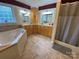 Bathroom featuring dual sinks, tile floor, vanity, and a luxurious soaking tub at 5570 George Henry Dr, Hickory, NC 28602