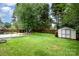 Large backyard features a lush green lawn and storage shed at 5711 Lambrook Ct, Charlotte, NC 28269