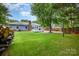 Expansive backyard featuring lush green lawn and patio with mature trees at 5711 Lambrook Ct, Charlotte, NC 28269