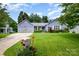 Landscaped front lawn features a lush yard, mailbox with flower bed, and a charming one-story periwinkle blue home at 5711 Lambrook Ct, Charlotte, NC 28269