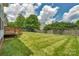 Large backyard with a well-maintained lawn and a classic wooden fence at 7800 Conifer Cir, Indian Trail, NC 28079