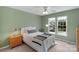 Cozy bedroom with soft green walls, white accents, and natural light from two windows at 7800 Conifer Cir, Indian Trail, NC 28079