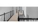 Second-floor hallway with neutral carpeting, railing with dark wood and gray stairs at 7800 Conifer Cir, Indian Trail, NC 28079