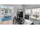 Office boasts a large desk, sleek black furniture, a view to the sunroom and plenty of sunlight at 7800 Conifer Cir, Indian Trail, NC 28079