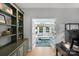 Home office showing built-in shelving and a view of the sunroom with French doors at 7800 Conifer Cir, Indian Trail, NC 28079