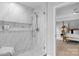 Modern bathroom shower with marble tile, glass door, and views into main bedroom at 7800 Conifer Cir, Indian Trail, NC 28079