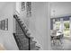 Elegant staircase with geometric-patterned carpet and views into a dining room with modern light fixtures at 7800 Conifer Cir, Indian Trail, NC 28079