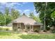 Backyard view of the home, showcasing its cozy exterior, tree coverage, and partially fenced yard at 816 Fulton St, Albemarle, NC 28001