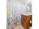 Cozy bathroom featuring a wood vanity, floral shower curtain, and neutral walls at 816 Fulton St, Albemarle, NC 28001