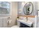 Stylish half-bathroom with wood trim, vanity, sink, mirror, and patterned wallpaper at 827 Ashwyn Dr, Charlotte, NC 28211