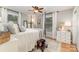 Comfortable bedroom featuring four-poster bed, hardwood floors, dresser and window at 827 Ashwyn Dr, Charlotte, NC 28211