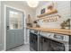 Well-equipped laundry room with wooden countertop, hanging rack, and modern machines at 827 Ashwyn Dr, Charlotte, NC 28211