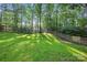 The grassy backyard is surrounded by mature trees and wood fencing, offering plenty of privacy at 8805 Deerland Ct, Huntersville, NC 28078