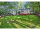 The lush backyard has a wooden deck, swing set, fire pit, and mature trees, providing space to enjoy the outdoors at 8805 Deerland Ct, Huntersville, NC 28078