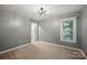 This bedroom is painted in neutral colors and features a modern ceiling fan and a sunlit window at 8805 Deerland Ct, Huntersville, NC 28078