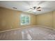 The spacious bedroom features a ceiling fan and a window that provides natural light at 8805 Deerland Ct, Huntersville, NC 28078