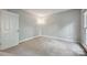 Simple bedroom with neutral carpet, paint, and a window at 8805 Deerland Ct, Huntersville, NC 28078