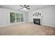 Spacious living room featuring fireplace, neutral carpet, and large window at 8805 Deerland Ct, Huntersville, NC 28078