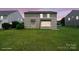 Back exterior of house displays large, well-maintained lawn and siding at 8915 Merrie Rose Ave, Charlotte, NC 28213